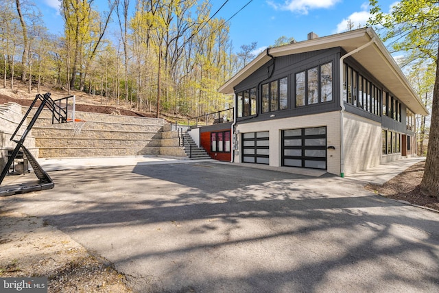 1335 N Pegram St N, Alexandria, VA 22304 - view of home's exterior featuring brick siding, a garage, driveway, and stairway