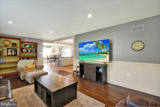 living room with recessed lighting, visible vents, wainscoting, and wood finished floors