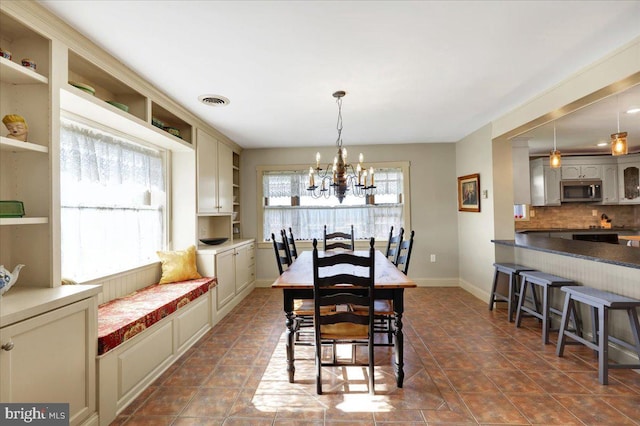 dining area with an inviting chandelier, baseboards, and visible vents