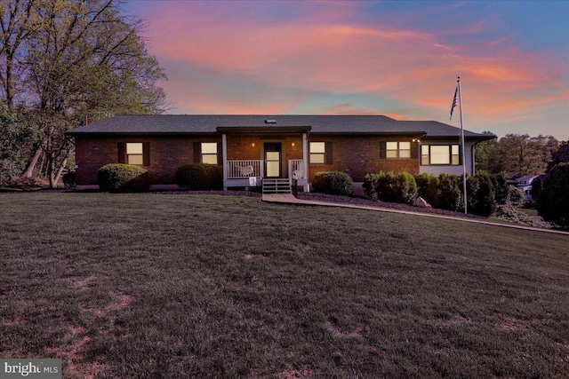 single story home with brick siding and a front yard