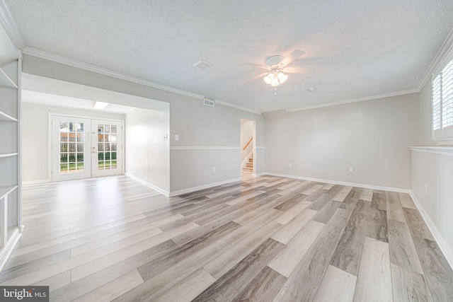 unfurnished room featuring a textured ceiling, visible vents, stairs, ceiling fan, and light wood-type flooring