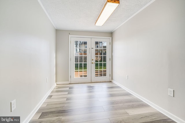 spare room with french doors, crown molding, a textured ceiling, and wood finished floors