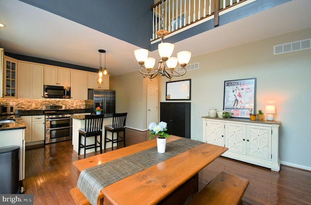dining room featuring a chandelier, baseboards, dark wood-style floors, and visible vents