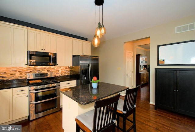 kitchen featuring visible vents, dark wood-style flooring, black fridge with ice dispenser, range with two ovens, and backsplash