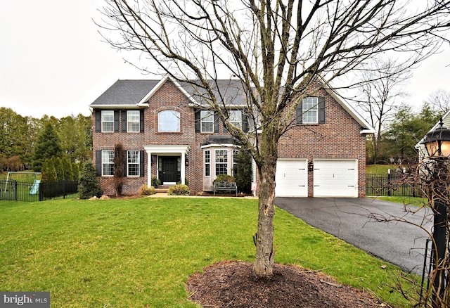 colonial-style house with a front yard, driveway, fence, and an attached garage