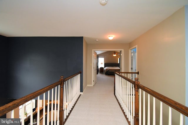 corridor featuring an upstairs landing, baseboards, and carpet floors