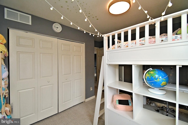 bedroom with carpet flooring, visible vents, and a closet