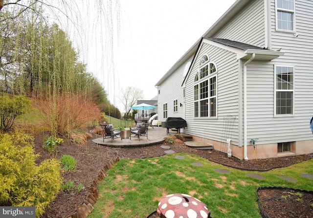 view of side of home with a patio area and a lawn