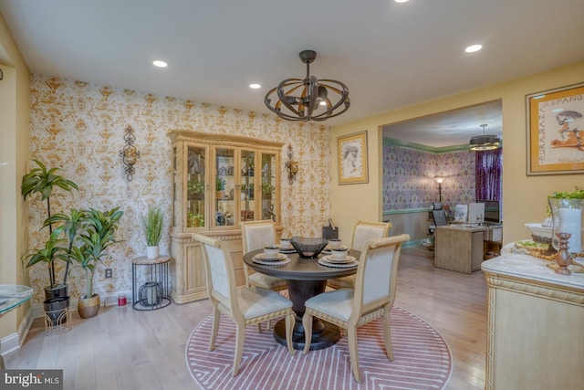 dining space with wallpapered walls, light wood finished floors, baseboards, recessed lighting, and a chandelier