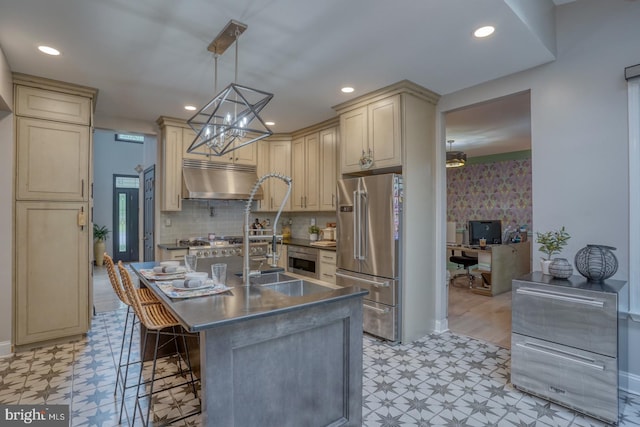 kitchen featuring freestanding refrigerator, light flooring, cream cabinets, a chandelier, and dark countertops