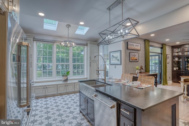 kitchen with stainless steel appliances, a skylight, a sink, plenty of natural light, and recessed lighting