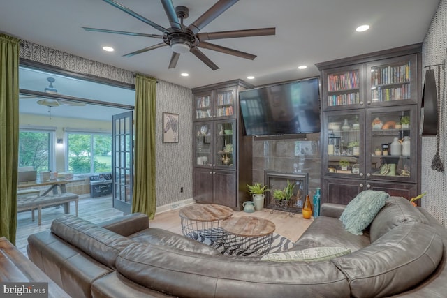 living room featuring wallpapered walls, a ceiling fan, a tiled fireplace, wood finished floors, and recessed lighting