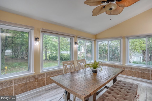 sunroom / solarium featuring vaulted ceiling and wood finished floors