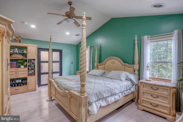 bedroom featuring vaulted ceiling, light wood-style flooring, and a ceiling fan