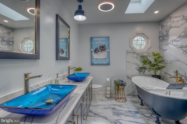 full bathroom featuring a skylight, marble finish flooring, plenty of natural light, and recessed lighting