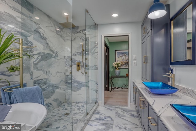 bathroom featuring marble finish flooring, a marble finish shower, double vanity, and a soaking tub