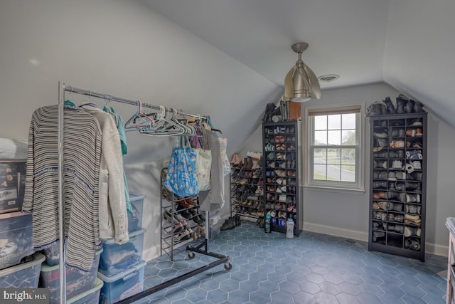 walk in closet with vaulted ceiling and tile patterned floors