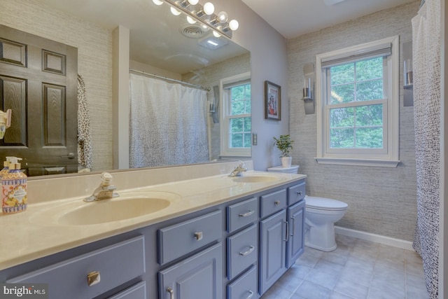 bathroom featuring toilet, double vanity, baseboards, wallpapered walls, and tile patterned flooring
