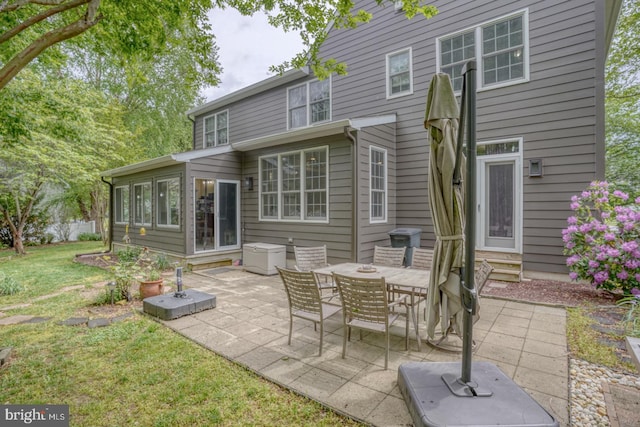 back of property with entry steps, a patio, and a yard