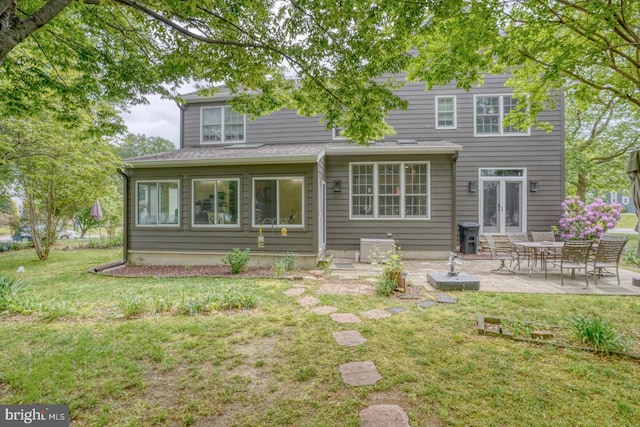 rear view of house with a patio, a lawn, and entry steps