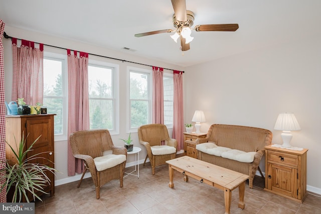sitting room featuring light tile patterned floors, baseboards, visible vents, and ceiling fan