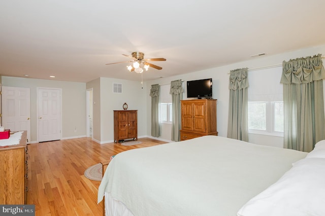bedroom with light wood-style flooring, visible vents, and multiple windows