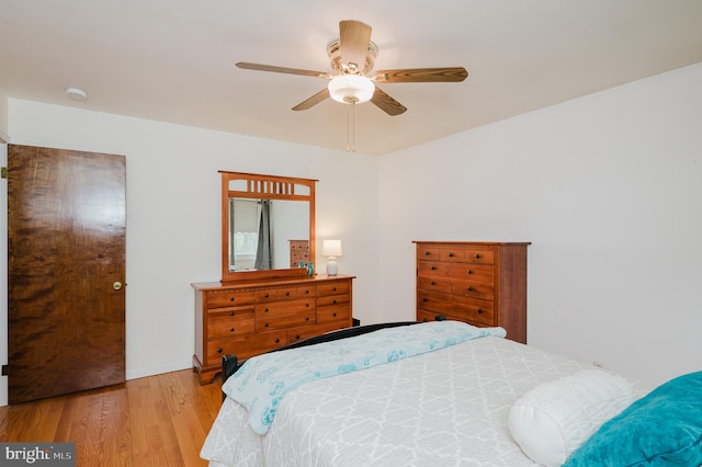 bedroom featuring wood finished floors, baseboards, and ceiling fan