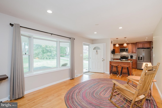 living room with light wood-type flooring, baseboards, and recessed lighting