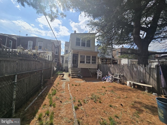 view of yard with entry steps and a fenced backyard