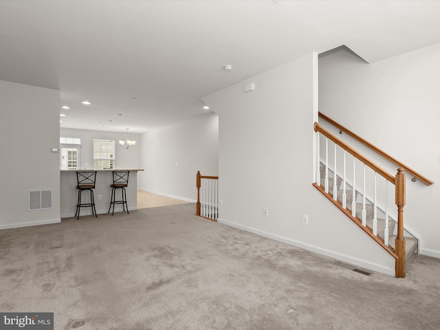 unfurnished living room with carpet, visible vents, recessed lighting, and a chandelier