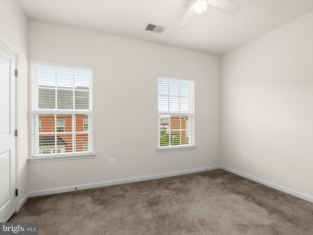 carpeted spare room featuring ceiling fan, baseboards, and visible vents