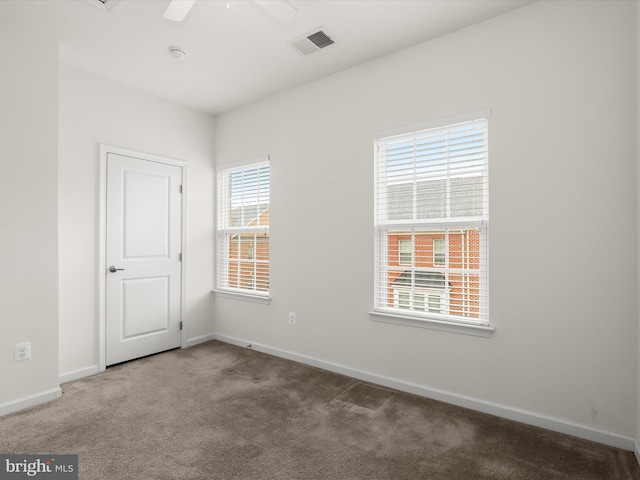 spare room with baseboards, visible vents, carpet, and ceiling fan