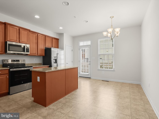 kitchen with an inviting chandelier, recessed lighting, pendant lighting, a kitchen island, and appliances with stainless steel finishes