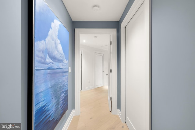 corridor with light wood finished floors and baseboards
