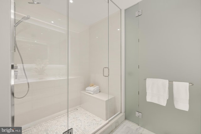 full bathroom with a shower stall and marble finish floors