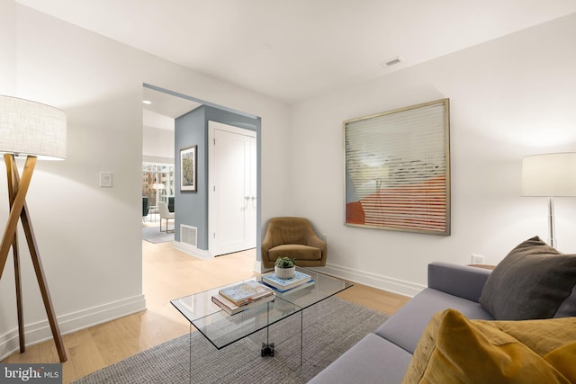 living area featuring light wood-style flooring and baseboards