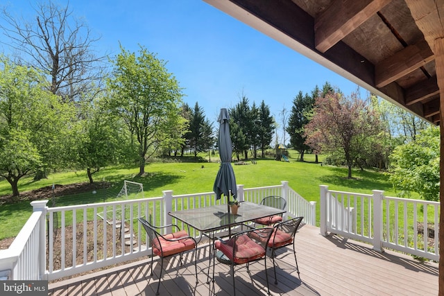 wooden deck featuring outdoor dining area and a yard