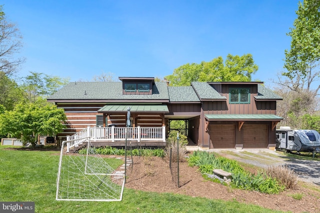 view of front of home with a garage, a front yard, a shingled roof, board and batten siding, and driveway