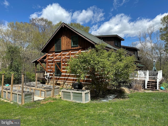exterior space featuring a lawn, a deck, and a garden