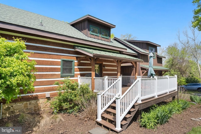 exterior space with a porch, board and batten siding, and a shingled roof