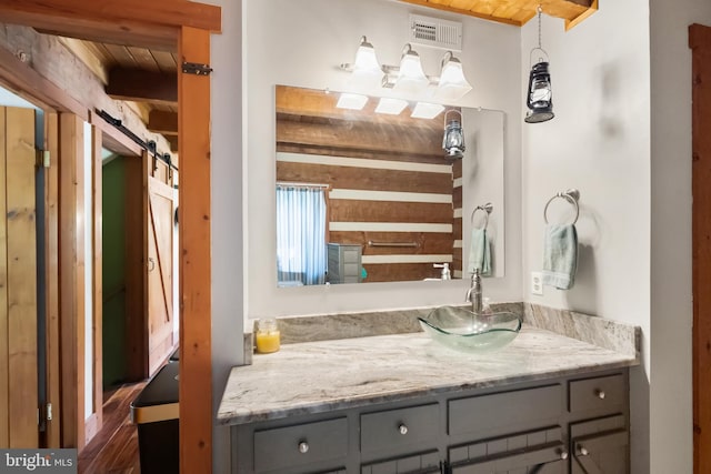 bathroom with vanity, wood ceiling, and visible vents