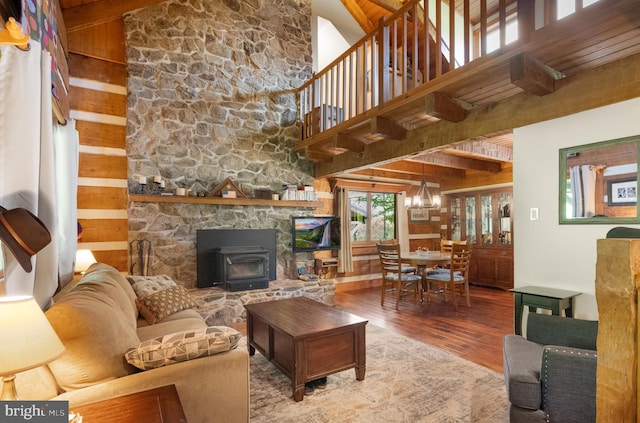 living room with wooden walls, beam ceiling, a chandelier, and hardwood / wood-style flooring