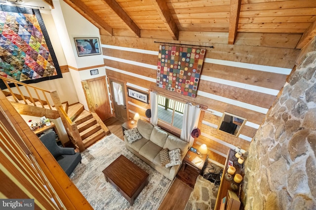 living room featuring wood walls, lofted ceiling with beams, wood ceiling, and wood finished floors