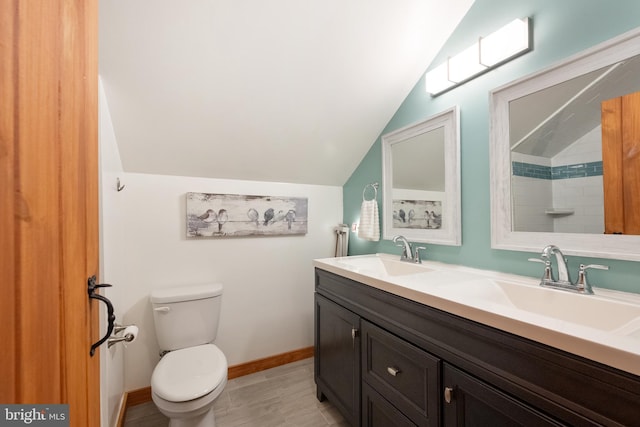full bath featuring double vanity, toilet, a sink, and lofted ceiling