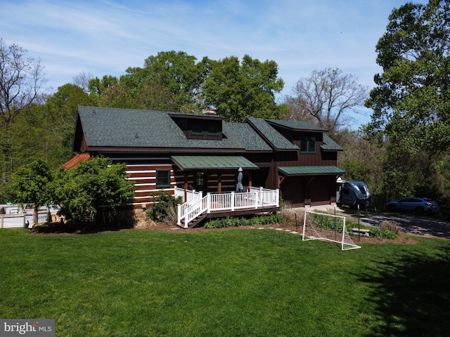 rear view of house featuring log siding, a shingled roof, and a yard