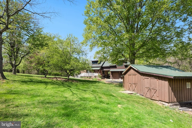 view of yard featuring a storage unit and an outbuilding