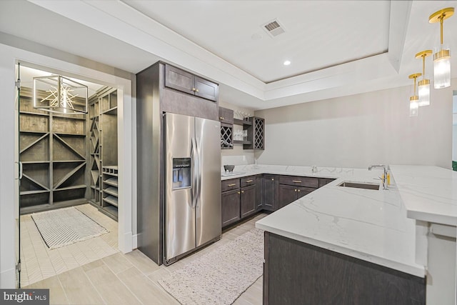 1109 Towlston Rd, Mclean, VA 22102 - kitchen featuring visible vents, a peninsula, stainless steel fridge, light stone counters, and a sink