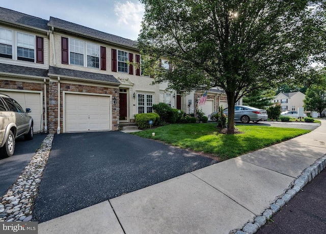 62 Brookview Ln, Pottstown, PA 19464 - view of property with stone siding, a front lawn, an attached garage, asphalt driveway, and roof with shingles