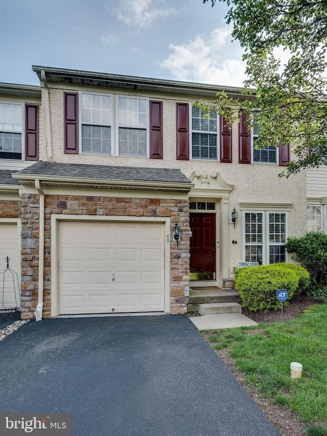 62 Brookview Ln, Pottstown, PA 19464 - view of property featuring an attached garage, driveway, stone siding, and stucco siding