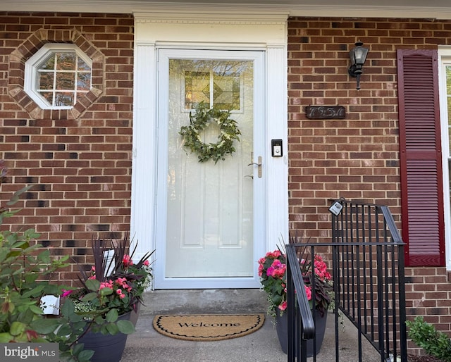 view of exterior entry featuring brick siding